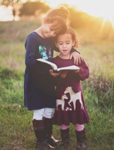 An adult reading with a child, representing the everyday people local charities support