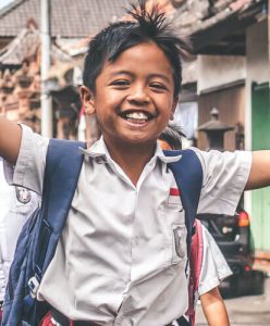 A student helped by a cause found on About Local Charities, smiling on his way to school